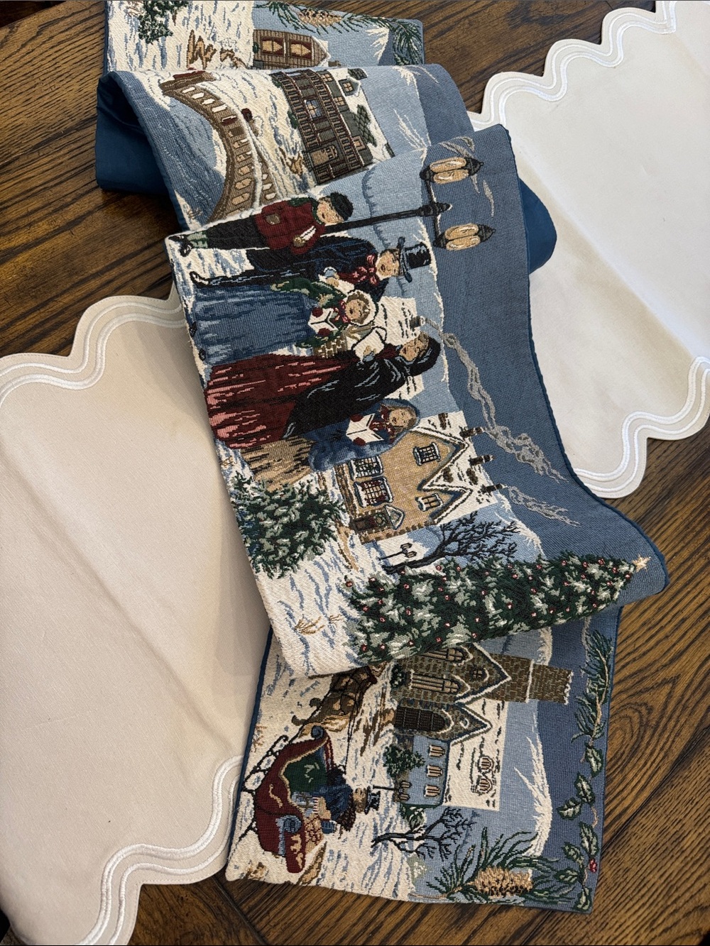 holiday-themed tapestry table runner featuring a snowy village 64”